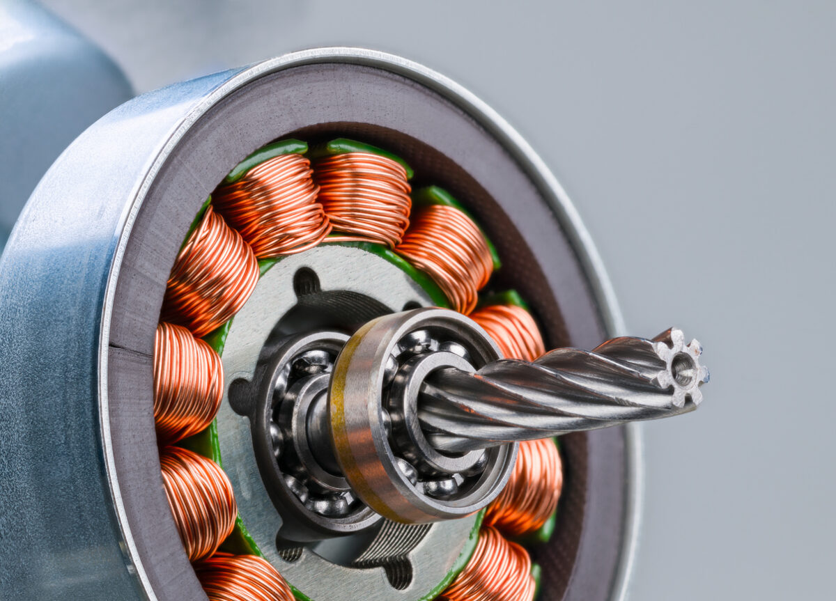 Closeup of electric motor rotor with worm gear, ball bearing and inductors on a gray background